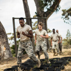 Young military soldiers practicing tyre obstacle course at boot camp